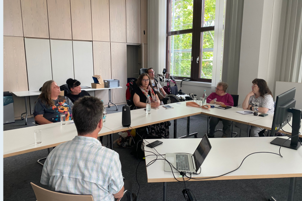 Regional-Sprecher sitzen mit Ellen Kubica an einem Tisch zusammen