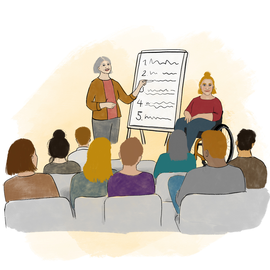 Zwei Personen, eine mit und eine ohne Rollstuhl, stehen neben einem Flipchart und halten einen Vortrag. Im Vordergrund sind – von hinten – die zuhörenden Menschen auf Stühlen zu sehen.
